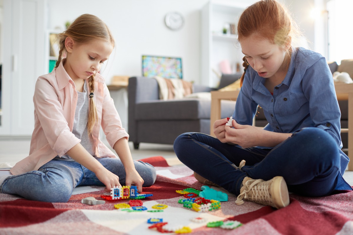 two girls playing indoors children toys